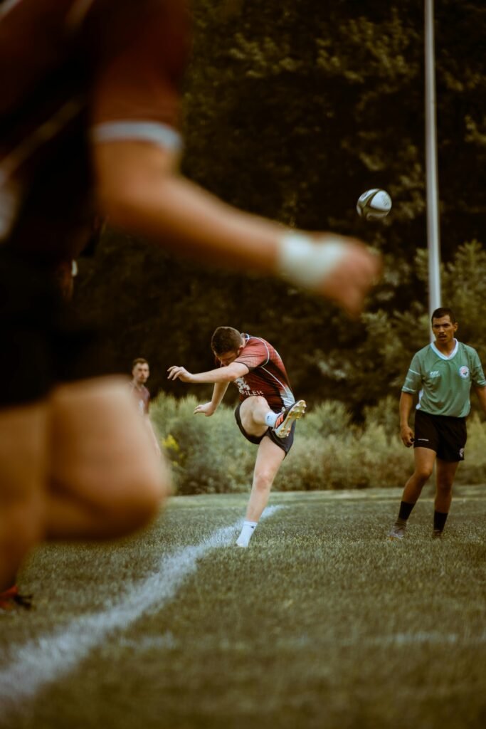 Athletes competing in an intense rugby match on a grassy field, showcasing action and movement.